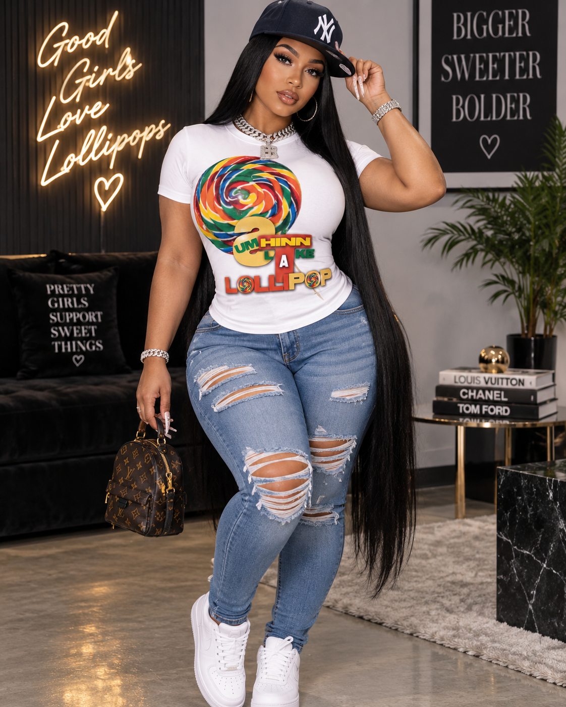 Woman wearing a white Summthinnlikealolipop graphic tee with jeans and a black cap